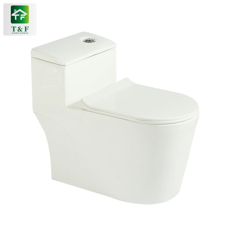 Bồn cầu màu trắng, thiết kế hiện đại, nắp đóng mềm, nút xả tròn trên bồn nước.