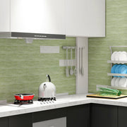 Nhà bếp hiện đại với tường gạch xanh, bếp ga, ấm đun nước trắng, và kệ đĩa bên cạnh.