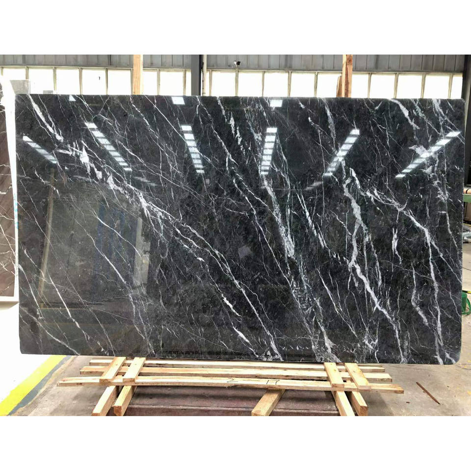 Phiến đá cẩm thạch đen với vân trắng nổi bật, đặt trên kệ gỗ trong nhà xưởng.