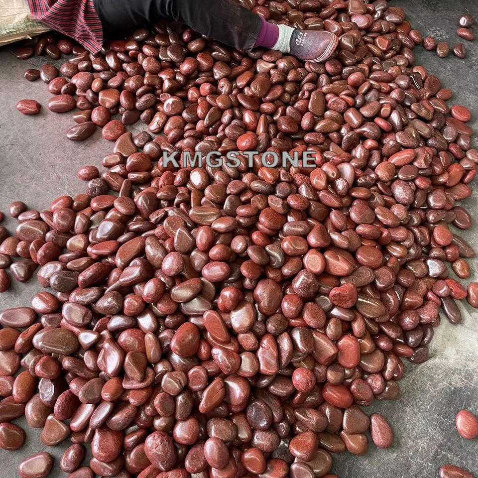 Hàng trăm viên đá đỏ nâu, bóng loáng nằm trên nền xi măng; một phần chân người bên trái.