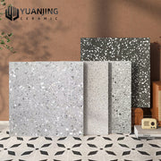 Bốn tấm gạch terrazzo màu xám nhạt đến đậm, nền tường nâu, nền gạch hoa văn đen trắng.