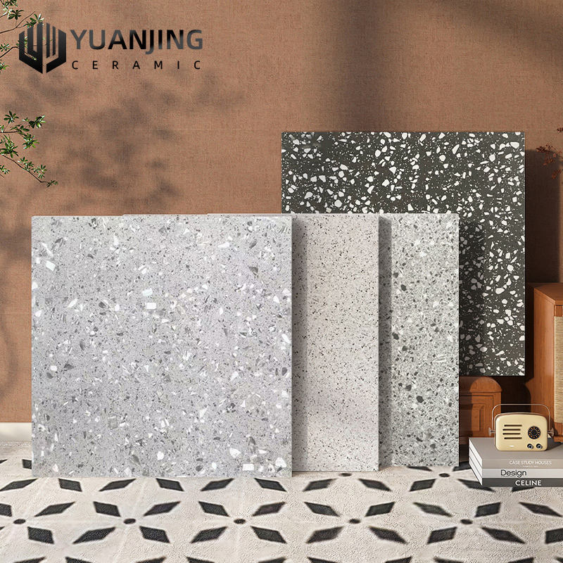Bốn tấm gạch terrazzo màu xám nhạt đến đậm, nền tường nâu, nền gạch hoa văn đen trắng.