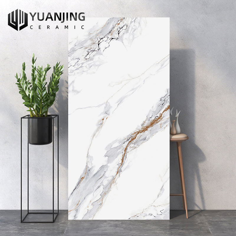 Tấm gạch men trắng vân đá, bên cạnh là chậu cây xanh trên kệ đen.