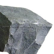 Mảnh đá màu xám đen, bề mặt thô ráp với cạnh sắc nhọn.