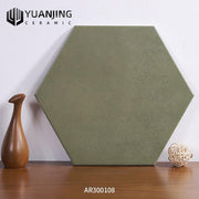 Gạch lục giác màu xanh olive đặt trên bàn gỗ, bên cạnh là bình và quả cầu trang trí.