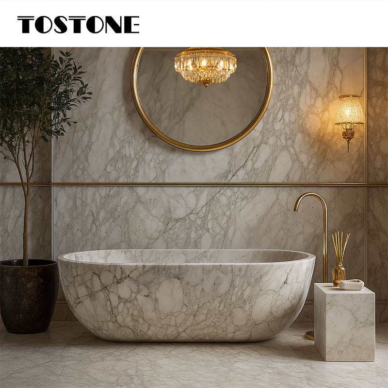 Bồn tắm đá cẩm thạch, đèn vàng ấm, gương tròn, tường đá cẩm thạch, cây xanh trong chậu.