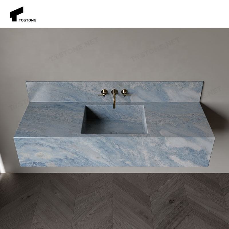 Bồn rửa màu xanh đá cẩm thạch với vòi nước vàng, nền tường xám và sàn gỗ tối màu.