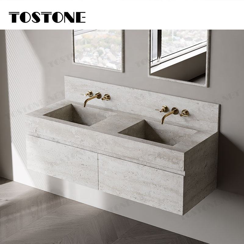 Bồn rửa đôi xi măng màu xám, vòi nước vàng, tường gương, ánh sáng tự nhiên chiếu vào.