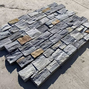 Các viên đá xếp chồng lẫn nhau, màu xám và nâu nhạt, tạo thành một bề mặt lát nền.