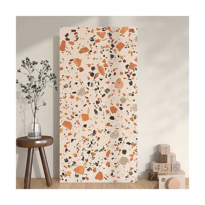 Tấm terrazzo màu kem với đốm cam, đen; bên cạnh là ghế gỗ và chậu cây nhỏ.