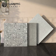 Ba mẫu gạch màu xám với họa tiết đốm, đặt trên nền gạch vuông sáng và sàn gỗ tối.