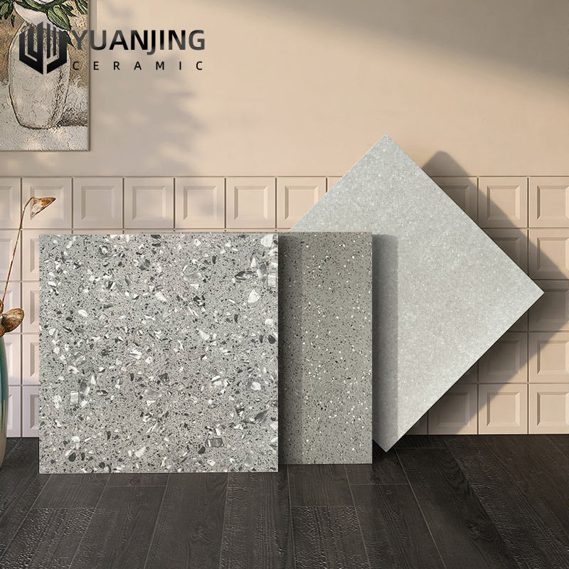 Ba mẫu gạch màu xám với họa tiết đốm, đặt trên nền gạch vuông sáng và sàn gỗ tối.
