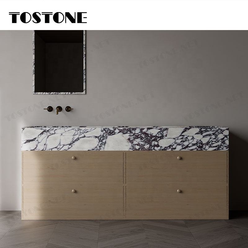 Tủ gỗ với mặt đá cẩm thạch vân đen trắng, có hai ngăn kéo, tường nền xám nhạt.