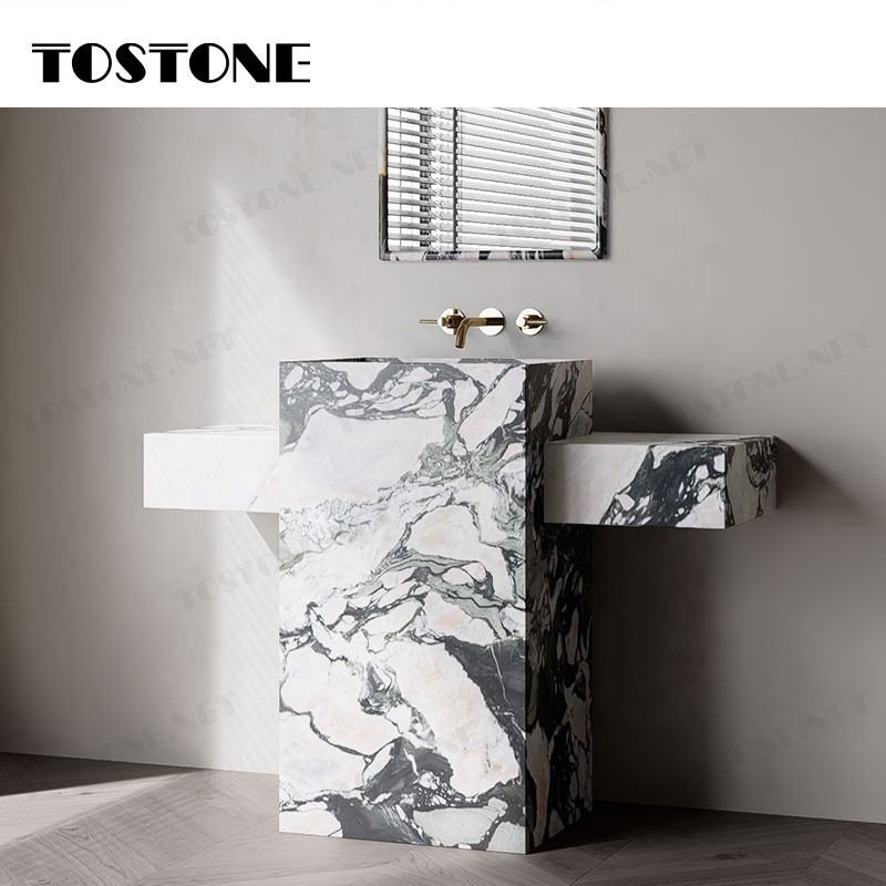 Bồn rửa bằng đá cẩm thạch vân xám trắng, vòi nước kim loại bóng, gương treo trên tường.