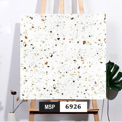 Bức tranh terrazzo với nền trắng, họa tiết đa sắc cam, xanh lá, đen, trên giá vẽ gỗ.