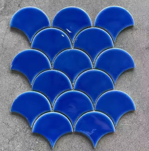Gạch men xanh dương hình vảy cá trên nền xám, sắp xếp thành hàng đối xứng.