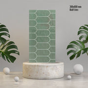 Gạch ốp tường xanh lá 300x600mm, họa tiết hình vòm, nền xám, kèm lá cây trang trí.