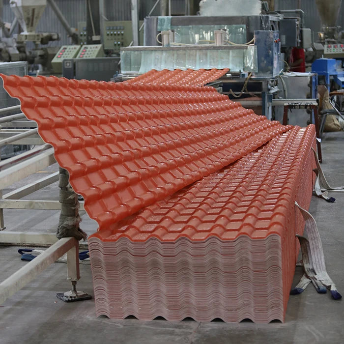 Tấm lợp sóng màu đỏ xếp chồng, nền xưởng công nghiệp với máy móc và thiết bị xung quanh.