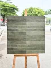 Bảng gạch màu xám xanh đặt trên giá gỗ, nền là cảnh đường phố và cây xanh.