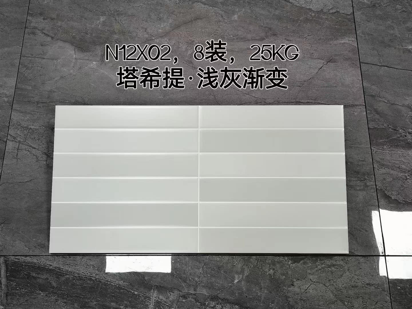 Gạch men trắng trên nền xám, dòng chữ Trung Quốc và ký hiệu N12X02, 25KG ở phía trên.