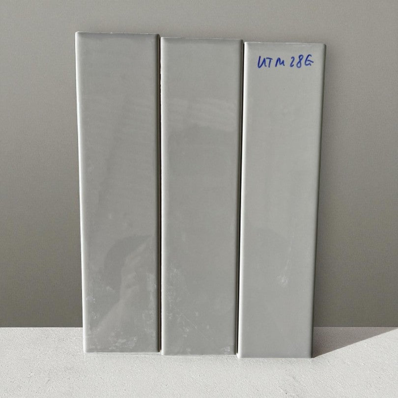 Ba viên gạch màu xám nhạt, dán thẳng đứng, một viên có mã viết tay màu xanh "UTM 28E".
