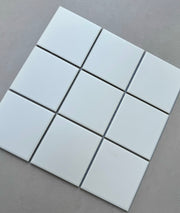 Chín viên gạch trắng hình vuông xếp 3x3 trên nền xám nhạt.